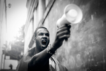 Black man with megaphone in protest .