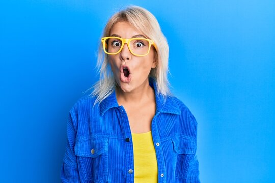 Young blonde girl wearing casual clothes and glasses scared and amazed with open mouth for surprise, disbelief face