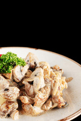 mashed potatoes with mushrooms in cream sauce herbs and tomatoes on a dark background