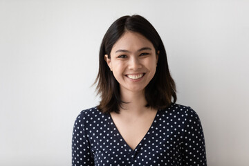 Profile picture of smiling millennial asian girl isolated on grey wall background look at camera...