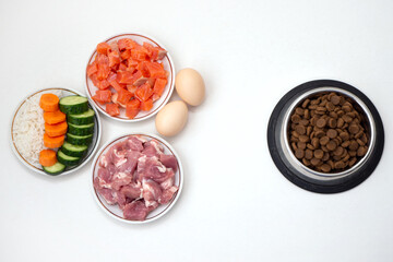 Dry pet dog food in bowl with natural ingredients. Raw meat, fish, vegetables, eggs and salad. concept of correct balanced and healthy nutrition for pet