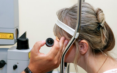 Woman UNERGO eyes test. Ocular fundus. Visit to the doctor.
