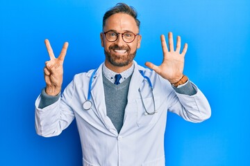 Handsome middle age man wearing doctor uniform and stethoscope showing and pointing up with fingers...