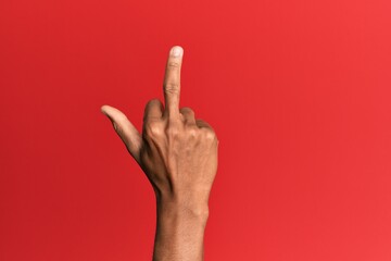 Hand of hispanic man over red isolated background showing provocative and rude gesture doing fuck...