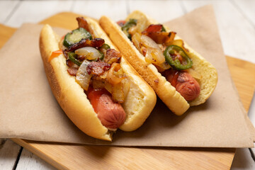 Hot dog with jalapeno pepper, bacon and caramelized onion on white background