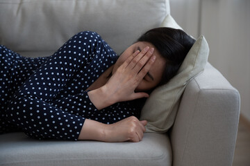 Depressed young woman lying on couch at home cry feeling lonely abandoned, struggle with divorce or...