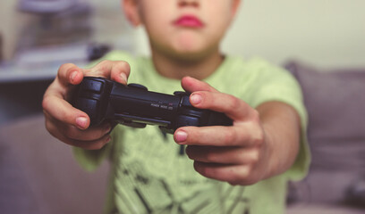 The boy is holding a gamepad in his hands.