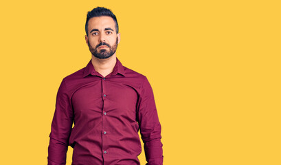 Young hispanic man wearing casual clothes with serious expression on face. simple and natural looking at the camera.