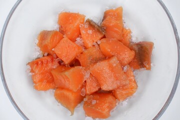 Pieces of salted trout fish with salt. Close up