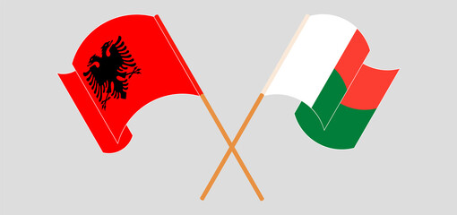 Crossed and waving flags of Madagascar and Albania