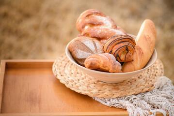 Composition from an assortment of fresh bread on a background of a mowed field of wheat.