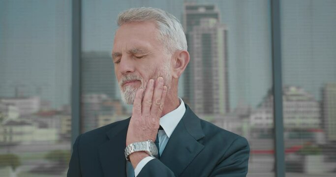 Mature office worker feeling toothache, gum inflammation, symptom of gingivitis