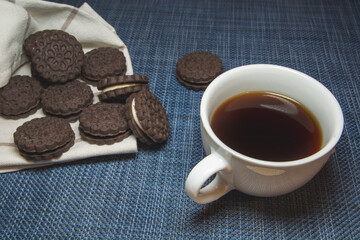 Coffee in a cup and cookies on a blue background
