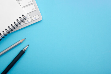 Blue desk office with laptop, smartphone and other work supplies with cup of coffee. Top view with copy space for input the text. Designer workspace on desk table essential elements on flat lay