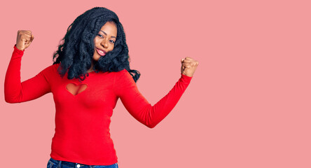 Beautiful african american woman wearing casual clothes showing arms muscles smiling proud. fitness concept.