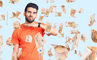 Young handsome man with beard wearing casual t-shirt cutting throat with hand as knife, threaten aggression with furious violence