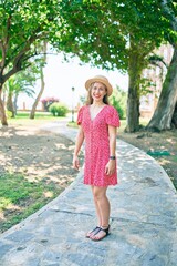 Young blonde woman on vacation smiling happy walking at the park