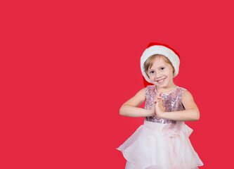Cute adorable smiling girl claps his hands for a gift isolated on red
