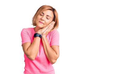 Young blonde woman wearing sportswear sleeping tired dreaming and posing with hands together while smiling with closed eyes.