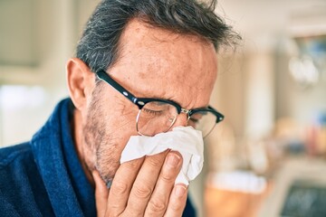 Middle age man feeling sick with cold and fever at home, ill with flu disease