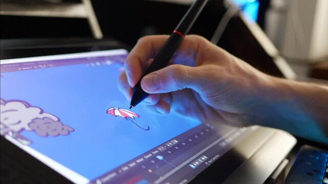 A creative digital artist animator in a studio using a touch pen drawing tablet and 3D animation software to create a simple graphic design.