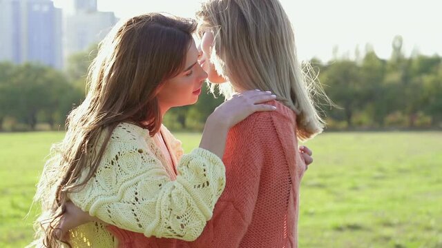 Female couple in love hugging outdoors. Slowmotion.
