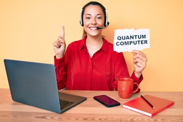 Young brunette woman holding quantum computer banner smiling with an idea or question pointing...