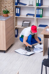 Young male contractor cleaning the office