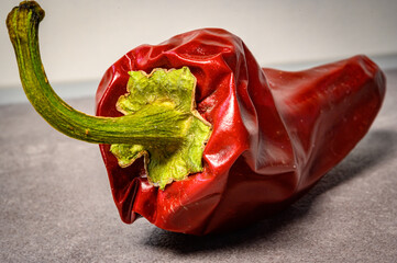 rote Chilischote auf grauem Hintergrund in der K&uuml;che, frische Zutat f&uuml;r kostliches Essen