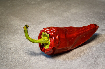 rote Chilischote auf grauem Hintergrund in der K&uuml;che, frische Zutat f&uuml;r kostliches Essen
