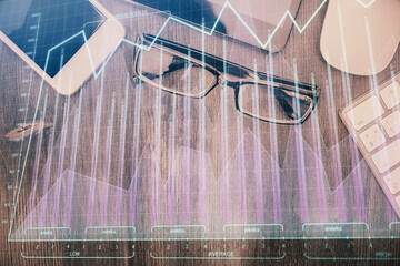 Multi exposure of forex graph hologram over desktop with phone. Top view. Mobile trade platform concept.