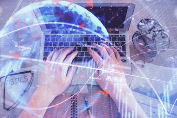Multi exposure of man's hands typing over computer keyboard and forex graph hologram drawing. Top view. Financial markets concept.