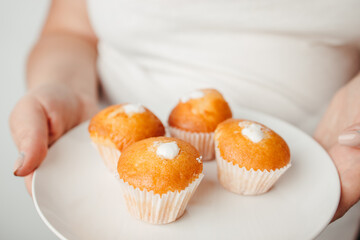 Overweight woman eating unhealthy sweet cupcakes