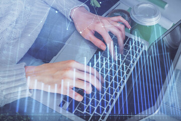 Double exposure of woman hands typing on computer and forex chart hologram drawing. Stock market invest concept.