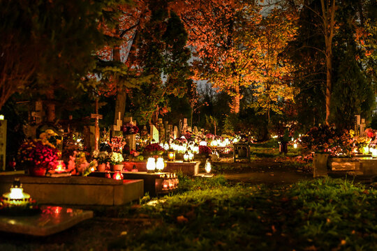 Christian cemetery with lit grave lights at night. Graveyard on All Saints' Day. 
