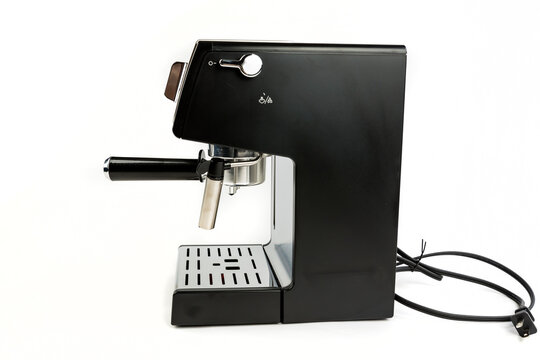 Black and silver espresso machine with cord coiled behind it side view with steaming wand to the front by filter holder