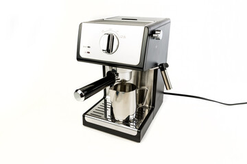 Espresso machine with filter in place and steaming cup below holder angled view