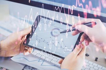 Double exposure of man's hands holding and using a phone and financial chart drawing. Market analysis concept.