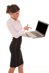 Office worker holds a laptop and points at it with a finger. A girl holds a laptop in her hand and shows her finger at a blank screen for reklama or logo.