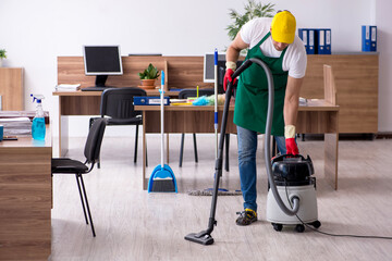 Young male contractor cleaning the office
