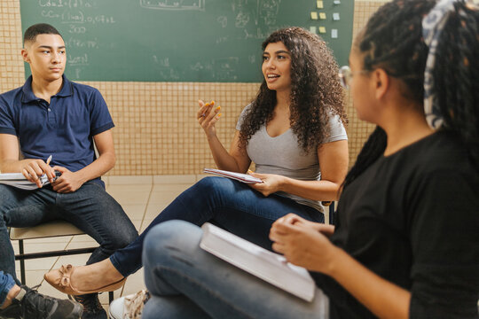 Latin students in the classroom. students doing group study. curly hair female student talking