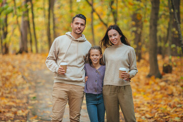 Fototapeta premium Portrait of happy family of three in autumn day