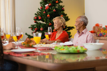 Summer Christmas dinner in Brazil. Real Brazilian family having fun at the Latin American Christmas party. elderly couple sitting at the dining table