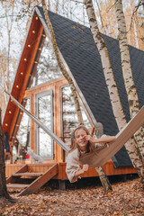 Beautiful girl having fun in hammock at autumn warm day