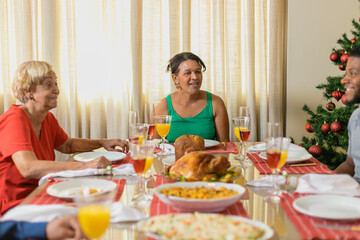 Summer Christmas dinner in Brazil. Real Brazilian family having fun at the Latin American Christmas party. latin woman and delicious christmas turkey