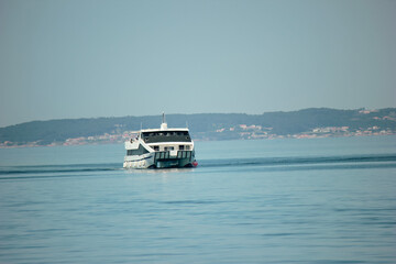 TOURIST FERRY SAILING THROUGH THE RIAS BAIXAS NEAR THE OYSTER PLATFORMS ON THE ISLAND OF LA TOJA, O GROVE, GALICIA, NORTH OF SPAIN IN SUMMER