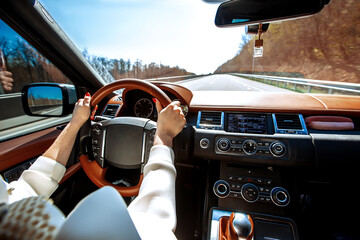 Young attractive blonde girl  sitting  in car and driving. Lifestyle and cars. Back view