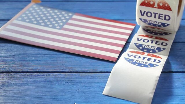 Woman's hand peeling a I Voted today sticker from a roll after voting