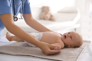 Fototapeta na wymiar Doctor examining cute baby in clinic, closeup. Health care
