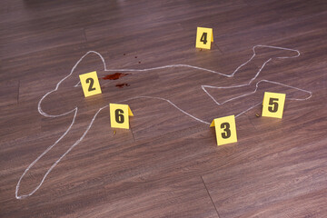 Crime scene with chalk outline of human body, blood, bullet shells and evidence markers on wooden...